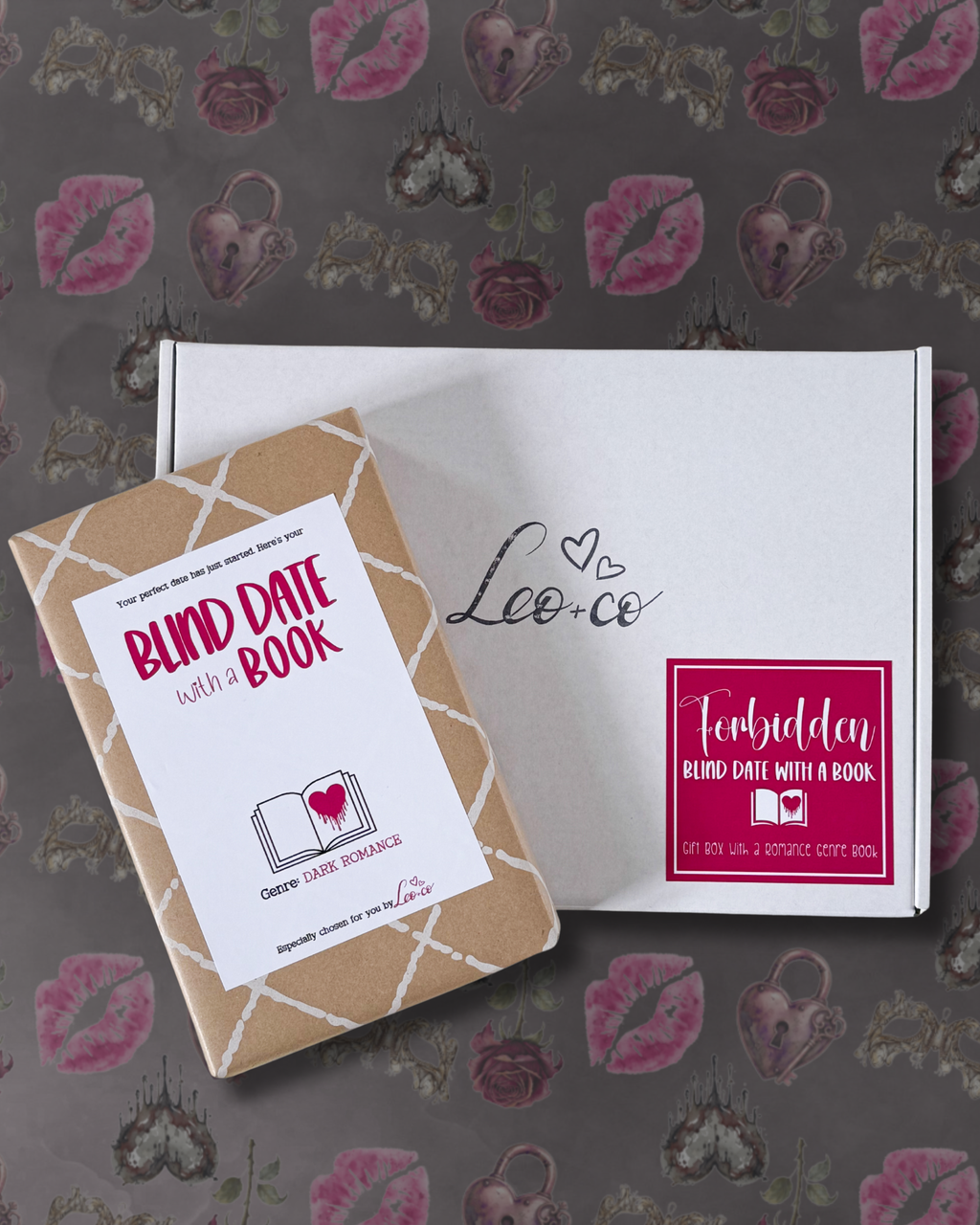 A boxed dark romance blind date with a book product displayed on a patterned grey background. The set includes a kraft paper book cover with a white label reading 'BLIND DATE with a BOOK' and a white box printed with 'Leo co' and a magenta 'Forbidden' badge.