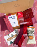 Christmas Blind Date With a Book gift box by Leo + Co, featuring a mystery book, cosy socks, shower steamer, Christmas wish bracelet, festive coaster, bookmark, self-heating eye mask and vegan gingerbread popcorn.